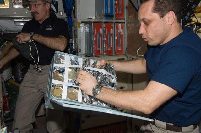 NASA image: Shkaplerov makes a selection from food container