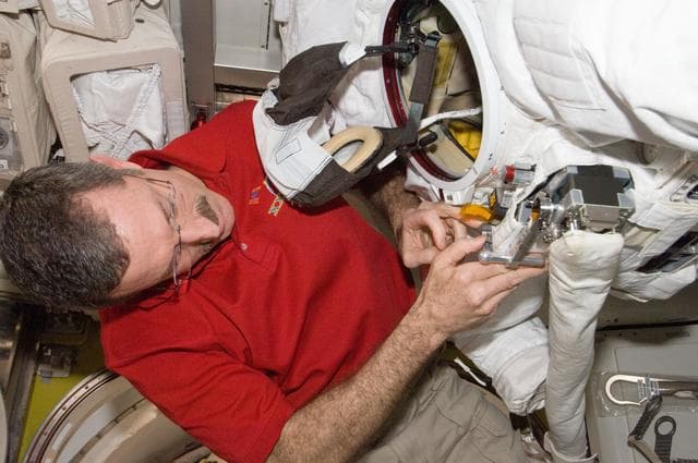 NASA image: Burbank performs routine in-flight maintenance on the EMU