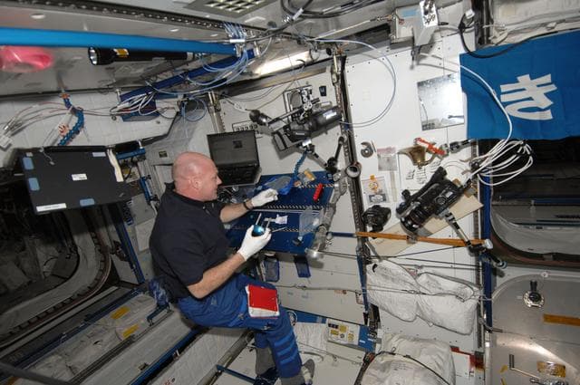 NASA image: Kuipers lubricates and cleans the beverage adapter on the PWD