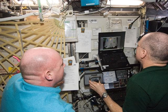NASA image: Pettit and Kuipers conducting RoBoT Simulator Session
