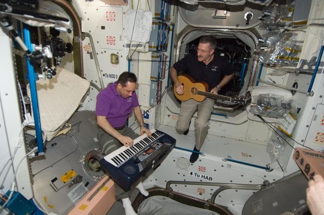 NASA image: Burbank and Shkaplerov playing musical instruments
