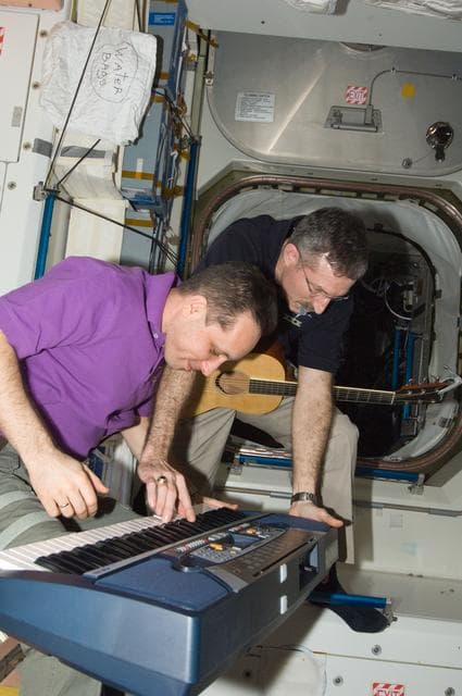 NASA image: Burbank and Shkaplerov with musical instruments