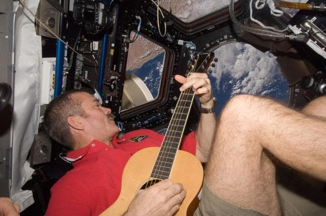 NASA image: Hadfield plays guitar in the Cupola Module