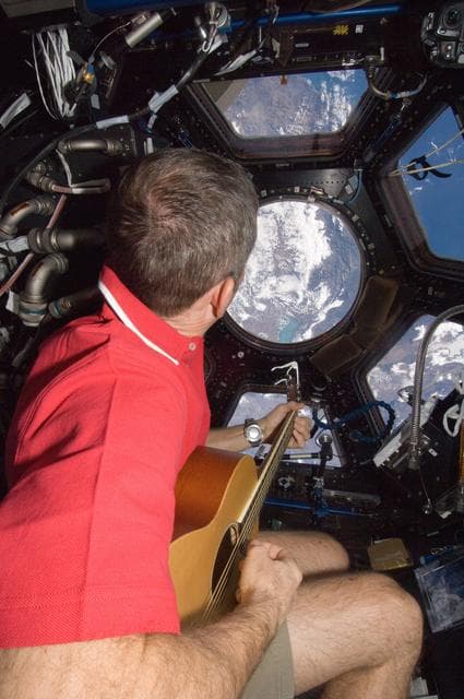 NASA image: Hadfield plays guitar in the Cupola Module