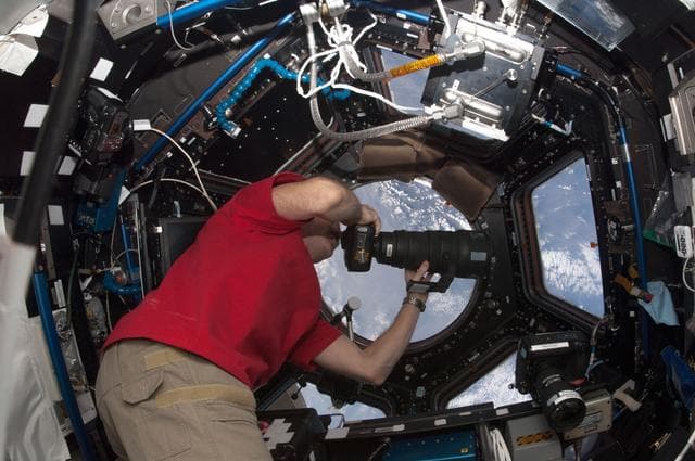 NASA image: Hadfield uses digital camera in the Cupola Module