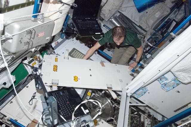 NASA image: Marshburn removes and replaces the WHC pre-treat tank during in-flight maintenance