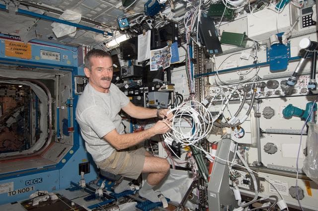 Hadfield wires the condensate transfer pump in the U.S. Laboratory