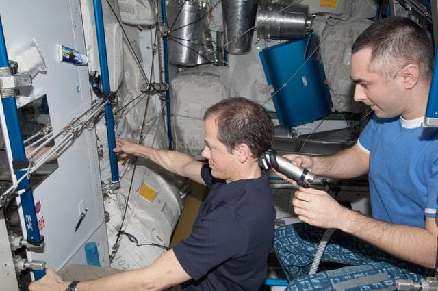 NASA image: Tarelkin gives Marshburn a haircut in the Node 3