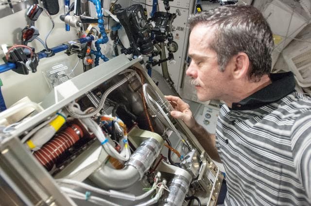 NASA image: Hadfield with the Reassembled Amine Swingbed in the U.S. Lab