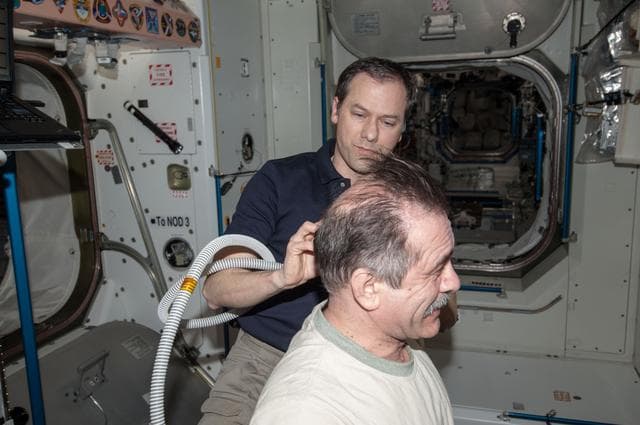 NASA image: Marshburn gives Vinogradov a haircut in Node 1