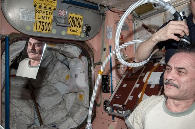 NASA image: Marshburn gives Vinogradov a haircut in Node 1