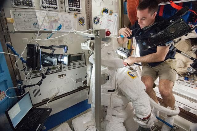 NASA image: working in airlock on EMU repairs