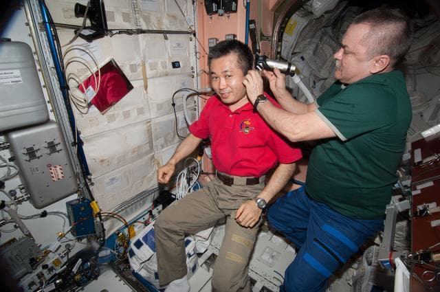 NASA image: Tyurin gives Wakata a Haircut in Node 1