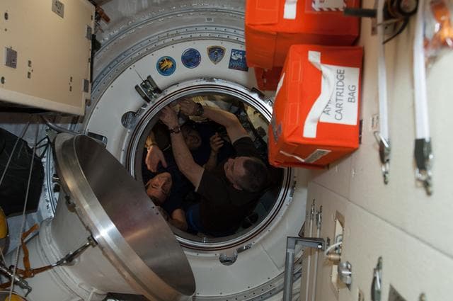 NASA image: Crewmembers during Soyuz TMA-11M Hatch Closing