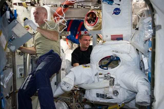 NASA image: Swanson and Wiseman in Airlock with EMU
