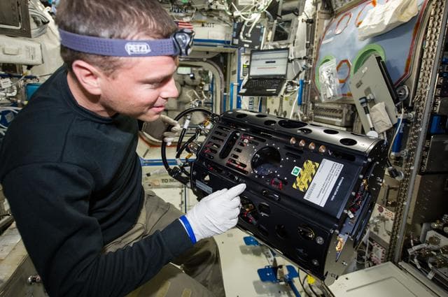 NASA image: Wiseman works with the MDCA hardware replacement, and CIR maintenance