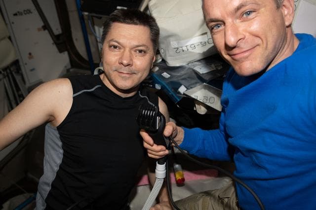 NASA image: David Saint-Jacques cuts Oleg Kononenko's hair