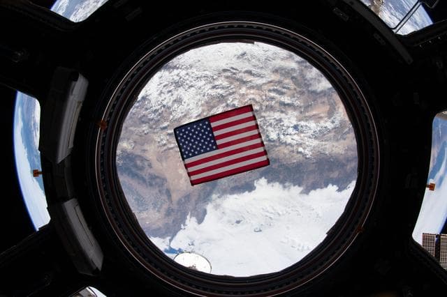 NASA image: U.S. flag in Cupola window