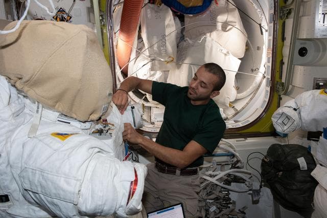 NASA image: UAE astronaut Sultan Alneyadi prepares a spacesuit for a spacewalk