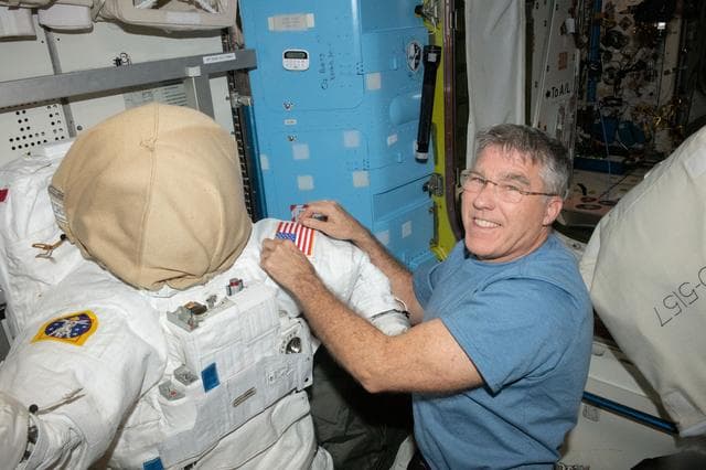 NASA image: NASA astronaut Stephen Bowen prepares a spacesuit for a spacewalk