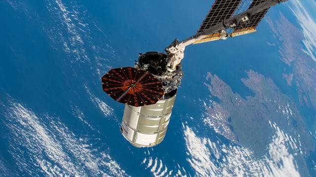 The Cygnus space freighter in the grip of the Canadarm2 robotic arm