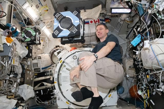 NASA image: Astronaut Woody Hoburg monitors an Astrobee robotic free-flyer