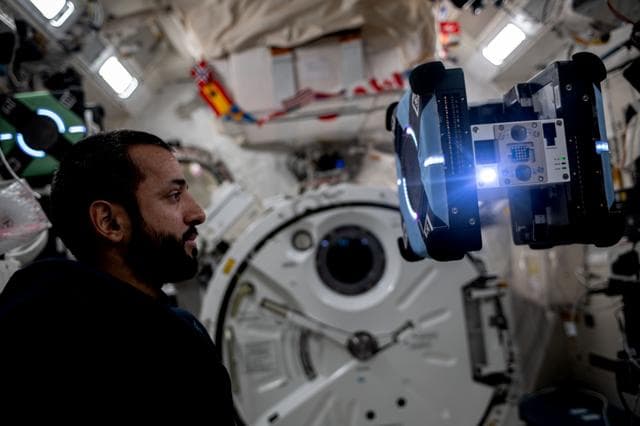 NASA image: Astronaut Sultan Alneyadi observes a free-flying Astrobee robotic assistant