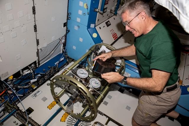 NASA image: Astronaut Stephen Bowen works on life support hardware