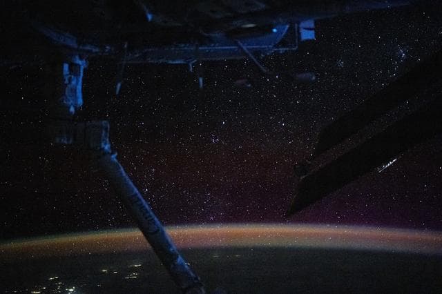 NASA image: The atmospheric glow blankets Earth beneath a sparkling field of stars