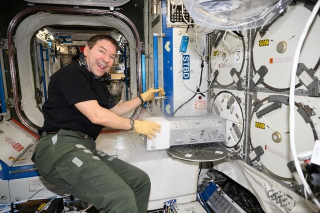 NASA image: Astronaut Mike Barratt stows research samples in a science freezer
