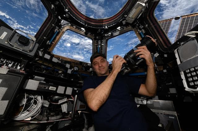 NASA image: Astronaut Matthew Dominick poses for a portrait in the cupola with his camera