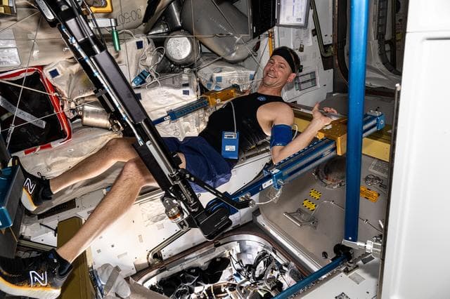 NASA image: Astronaut Nick Hague exercises on the advanced resistive exercise device