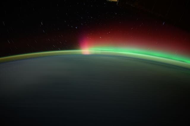 NASA image: Streaks of city lights, star trails, an aurora, and Earth's atmospheric glow