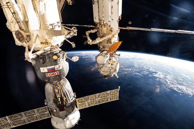 NASA image: The International Space Station soars into an orbital sunset above a cloudy Pacific Ocean