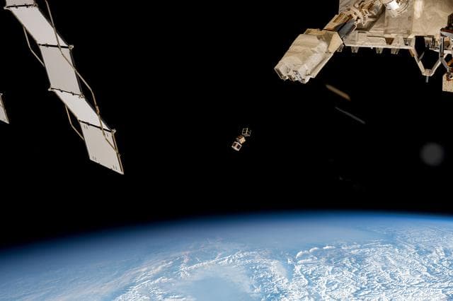 NASA image: A trio of CubeSats is ejected into Earth orbit from a small satellite orbital deployer