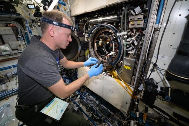 NASA image: Astronaut Nick Hague processes combustion experiment samples