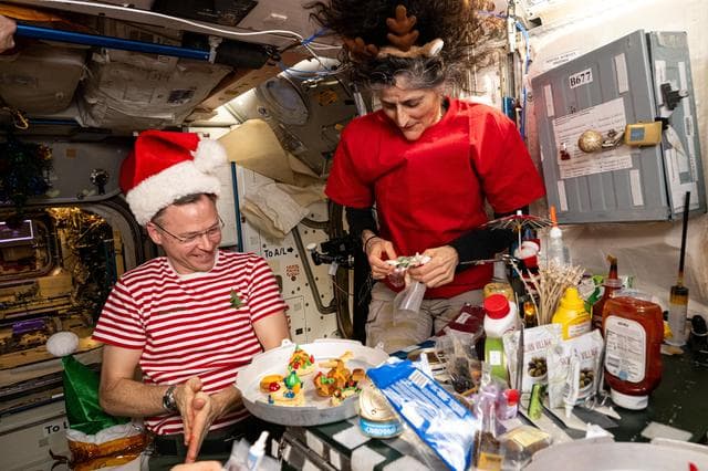 NASA image: Astronauts Nick Hague and Suni Williams share snacks and goodies on Christmas Eve