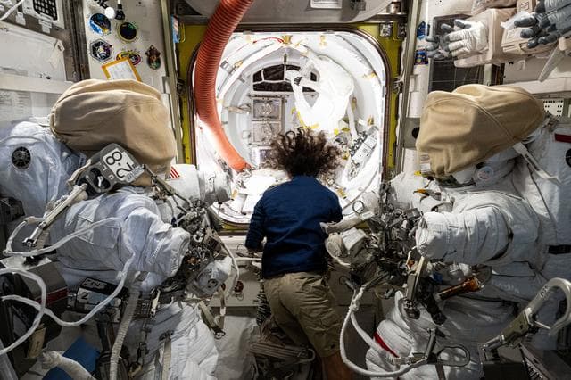 NASA image: Astronaut Suni Williams works in the Quest airlock readying a pair of spacesuit