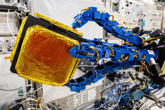 NASA image: An Astrobee robotic free-flyer with blue tentacle-like arms