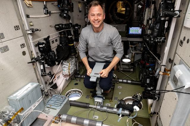 NASA image: Astronaut Nick Hague measures his mass using a specialized device
