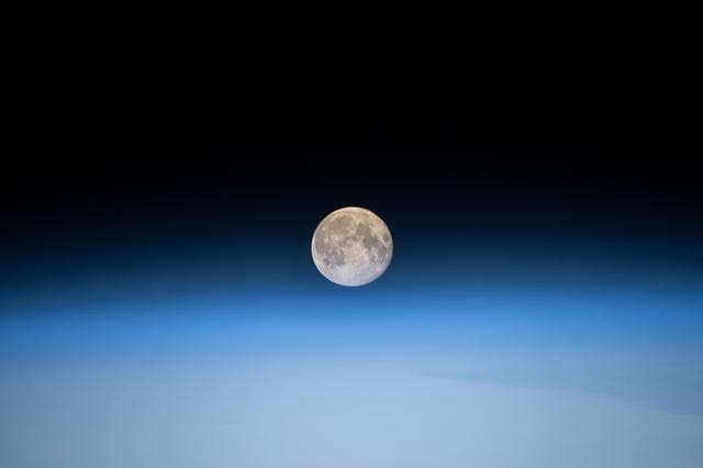 NASA image: The full Moon above Earth's horizon