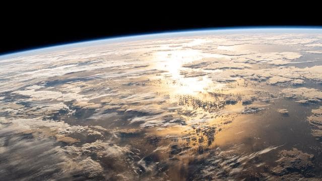 NASA image: The sun's glint beams off a partly cloudy Atlantic Ocean
