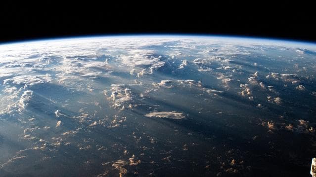 NASA image: A Southeast Asian sunrise casts long shadows behind clouds