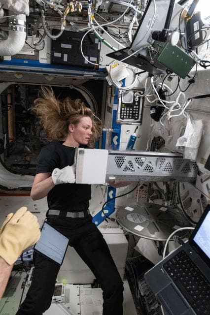 NASA image: Astronaut Nichole Ayers inserts blood samples into a science freezer