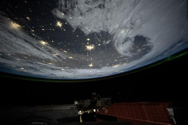 NASA image: City lights dot the cloudy, midwestern landscape of the United States