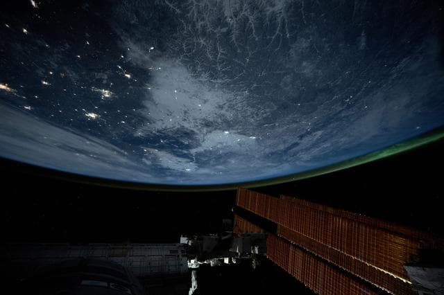 NASA image: City lights dot the northeastern landscape of China with a wispy aurora above Earth's horizon