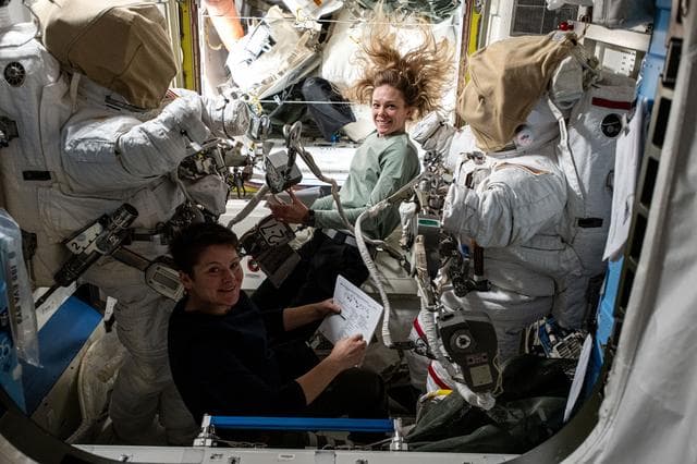 NASA image: Astronauts Anne McClain and Nichole Ayers checkout spacesuit hardware in the Quest airlock
