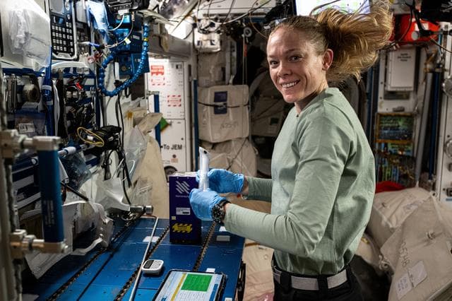 NASA image: Astronaut Nichole Ayers prepares mixture tubes containng research samples