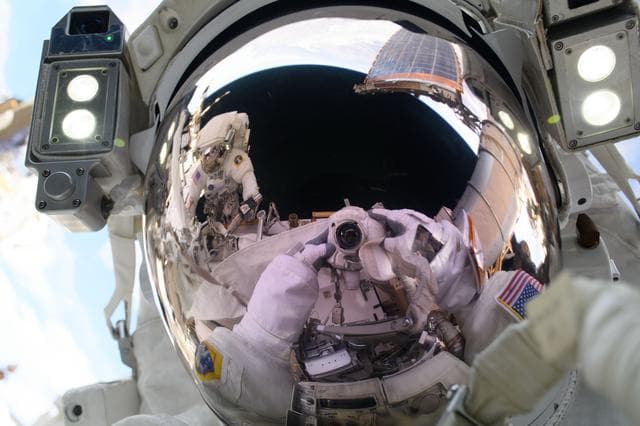NASA image: Astronaut Anne McClain points a camera towards herself and takes a "space-selfie"
