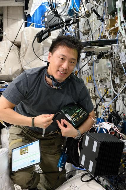 NASA image: NASA astronaut Jonny Kim works on computer networking maintenance
